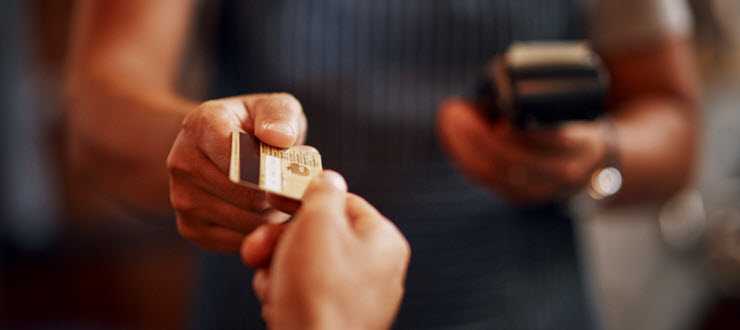 Man handing credit card to merchant