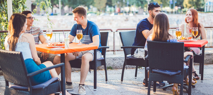 Group of patrons at different tables on outdoor patio