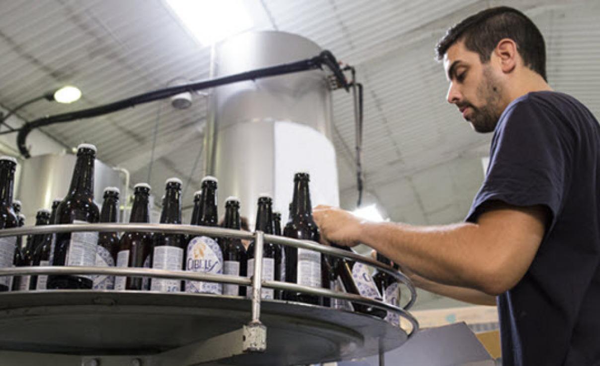 Man working on beer bottling machine